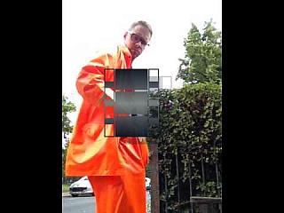 showing off orange rainwear and plastic suit